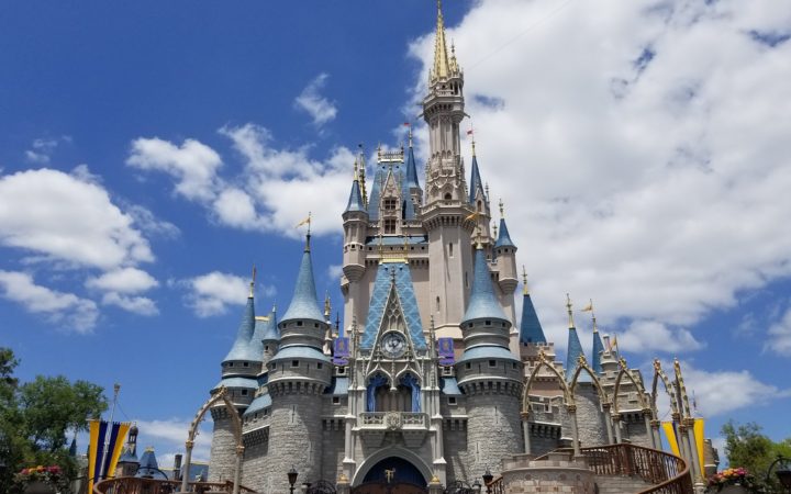 Cinderella Castle in Magic Kingdom on a sunny day with puffy clouds