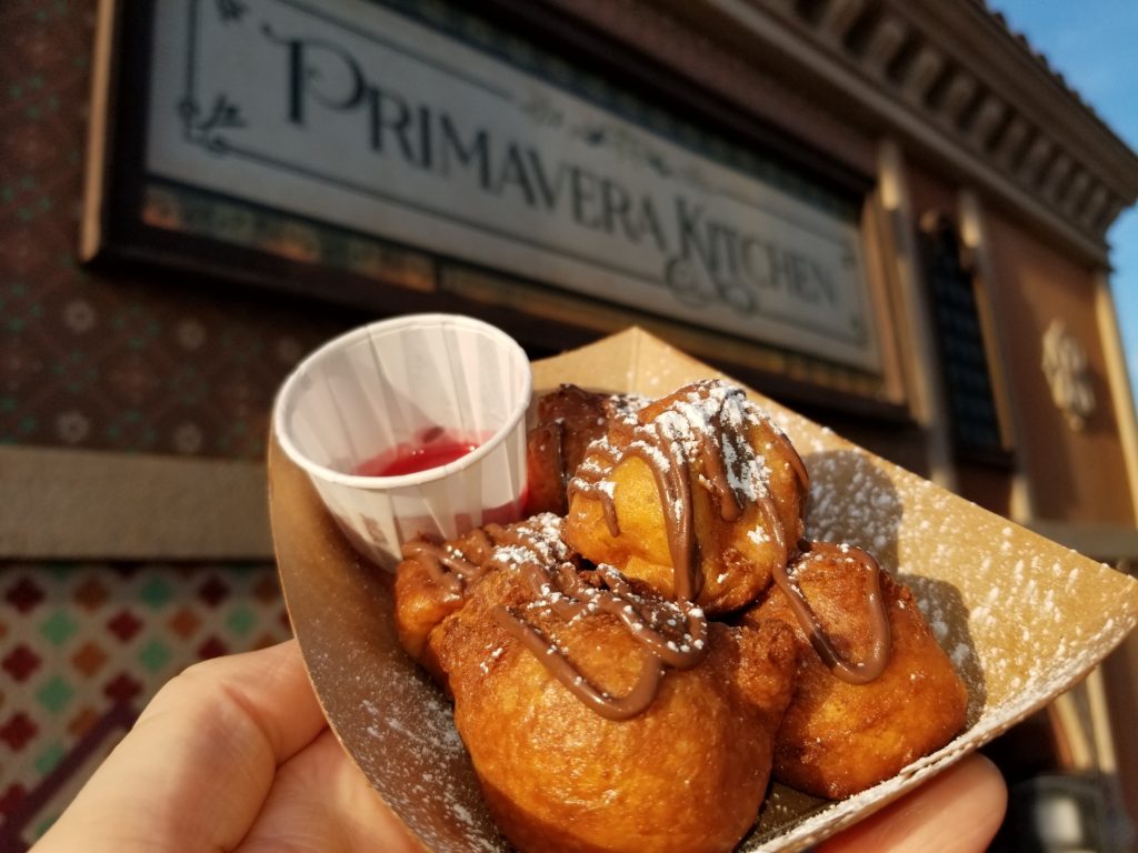 Zeppole: Ricotta Cheese Fritters, Powdered Sugar, Chocolate-Hazelnut Sauce and Raspberry Sauce in front of Primavera Kitchen in the Italy Pavilion