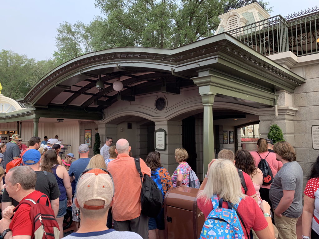 Adults and a few children lined up waiting to get into Magic Kingdom in Walt Disney World.