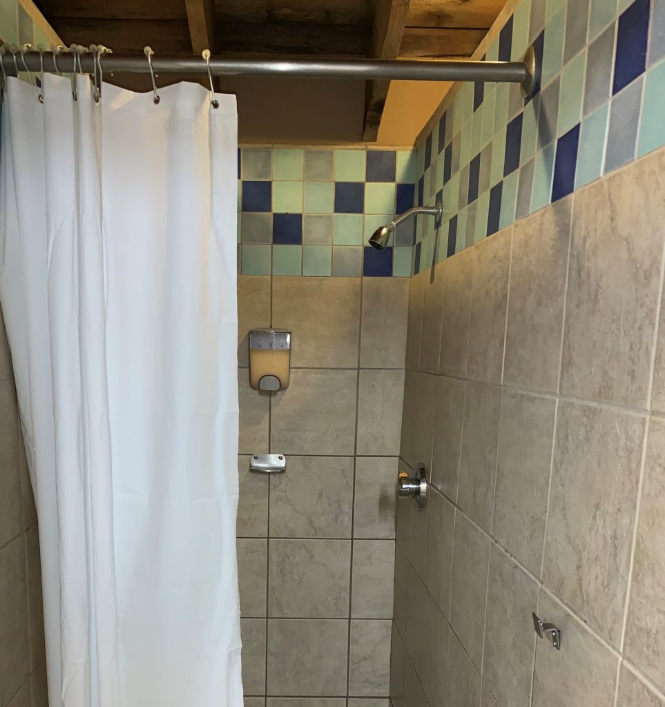 Image of a shower stall at Disney’s Blizzard Beach water park with only one hook on the wall.  