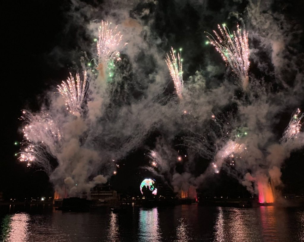 A water front view of IllumiNations: Reflections of Earth fireworks and fountains.