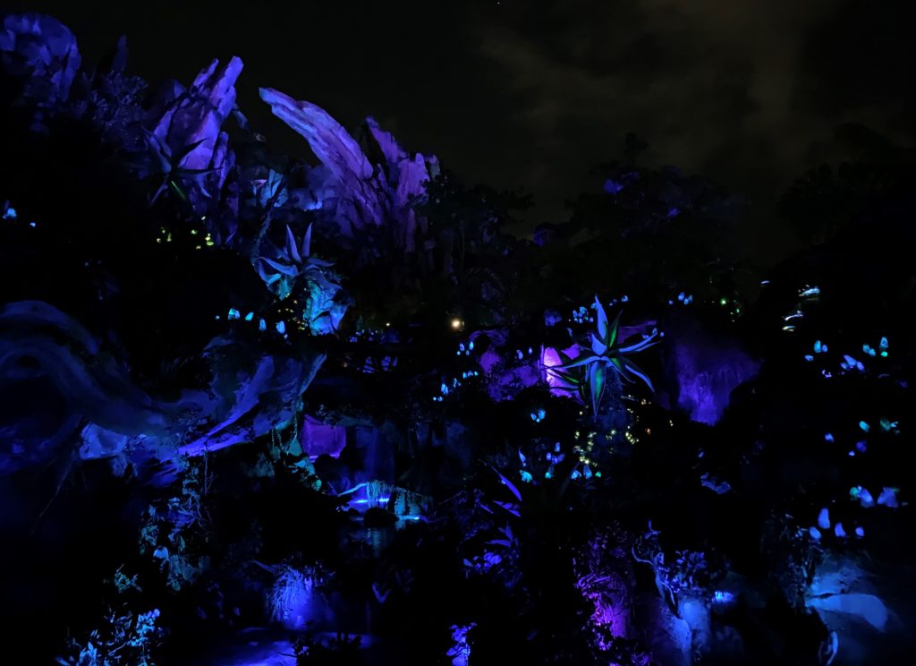 The mountains and waterfall in Pandora: The World of Avatar at Disney's Animal Kingdom at night.  They are lit up with bioluminescence, and they are glowing. 